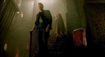 Movie still from “The City of Lost Children” (1995), directed by Jean-Pierre Jeunet – A man and a woman walking down a set of stairs; Wide shot, Low angle