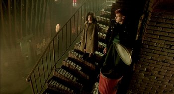 Movie still from “The City of Lost Children” (1995), directed by Jean-Pierre Jeunet – A man and a woman walking down a set of stairs; Wide shot, High angle