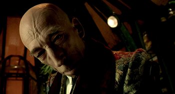 Movie still from “The City of Lost Children” (1995), directed by Jean-Pierre Jeunet – An old man with a bald head and a mustache; Close Up shot, Low angle