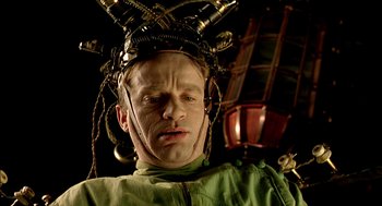 Movie still from “The City of Lost Children” (1995), directed by Jean-Pierre Jeunet – A man wearing a green shirt and a helmet; Close Up shot, Low angle