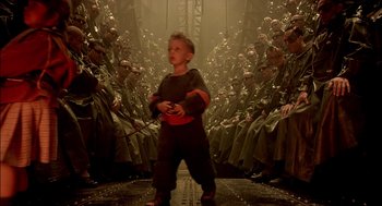 Movie still from “The City of Lost Children” (1995), directed by Jean-Pierre Jeunet – A young boy standing in front of a group of soldiers; Wide shot, High angle