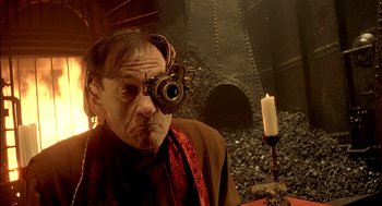 Movie still from “The City of Lost Children” (1995), directed by Jean-Pierre Jeunet – An older man wearing a scarf with a candle in the background; Close Up shot, Low angle