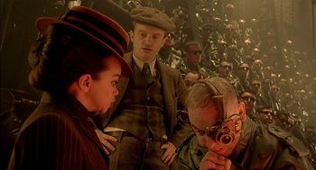 Movie still from “The City of Lost Children” (1995), directed by Jean-Pierre Jeunet – A group of people sitting in front of a group of men; Medium shot, Low angle