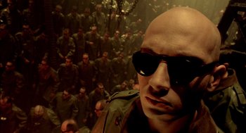 Movie still from “The City of Lost Children” (1995), directed by Jean-Pierre Jeunet – A man with sunglasses standing in front of a group of soldiers; Close Up shot, High angle