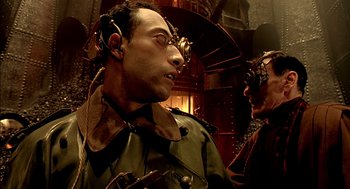 Movie still from “The City of Lost Children” (1995), directed by Jean-Pierre Jeunet – A man with a headset on and another man with a headset on; Close Up shot, Low angle