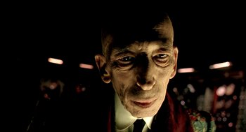 Movie still from “The City of Lost Children” (1995), directed by Jean-Pierre Jeunet – An old man wearing a suit and a tie; Close Up shot, Low angle