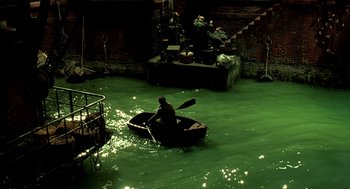 Movie still from “The City of Lost Children” (1995), directed by Jean-Pierre Jeunet – A man in a small boat in the water; Extreme Wide shot, High angle