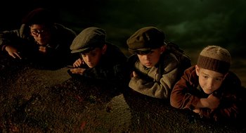 Movie still from “The City of Lost Children” (1995), directed by Jean-Pierre Jeunet – Two young boys laying on the ground looking at the camera; Medium shot, High angle