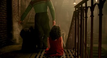 Movie still from “The City of Lost Children” (1995), directed by Jean-Pierre Jeunet – A woman sitting on the ground in front of a man; Medium shot, Low angle