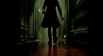 A woman walking down a dark hallway in the rain