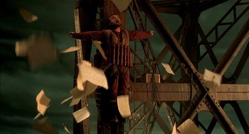 Movie still from “The City of Lost Children” (1995), directed by Jean-Pierre Jeunet – A man is flying through the air with papers flying around him; Wide shot, Low angle