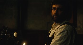 Movie still from “The Cobbler” (2014), directed by Tom McCarthy – A man with a beard is standing next to a lit candle; Close Up shot, Over the shoulder angle