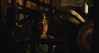 Movie still from “The Cobbler” (2014), directed by Tom McCarthy – A young boy sitting in front of a mirror in the dark; Medium shot, High angle