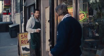Movie still from “The Cobbler” (2014), directed by Tom McCarthy – A man in an apron standing next to another man in an apron; Medium shot, Over the shoulder angle