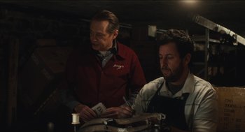 Movie still from “The Cobbler” (2014), directed by Tom McCarthy – Two men working in a workshop with a machine; Medium shot, Over the shoulder angle