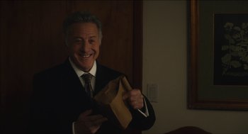 Movie still from “The Cobbler” (2014), directed by Tom McCarthy – A man in a suit and tie holding a brown bag; Medium shot, Over the shoulder angle