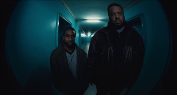 Movie still from “The Cobbler” (2014), directed by Tom McCarthy – Two men standing next to each other in a dark hallway; Medium shot, Low angle