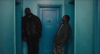 Movie still from “The Cobbler” (2014), directed by Tom McCarthy – Two men standing in front of a blue door; Medium shot, Low angle