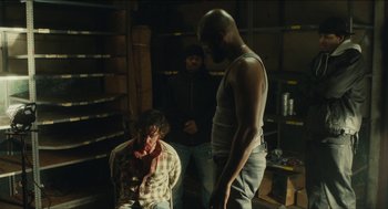 Movie still from “The Cobbler” (2014), directed by Tom McCarthy – A group of people standing around in a room; Medium shot, Over the shoulder angle