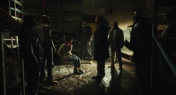 Movie still from “The Cobbler” (2014), directed by Tom McCarthy – A group of men standing around in a room; Wide shot, High angle