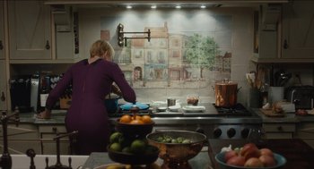 Movie still from “The Cobbler” (2014), directed by Tom McCarthy – A woman standing in front of a stove in a kitchen; Wide shot, Over the shoulder angle