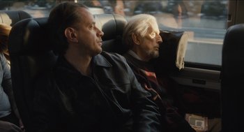 Movie still from “The Cobbler” (2014), directed by Tom McCarthy – Two men sitting in the back seat of a car; Medium shot, Over the shoulder angle