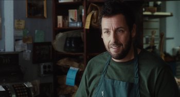 Movie still from “The Cobbler” (2014), directed by Tom McCarthy – A man wearing an apron standing in a room; Close Up shot, Over the shoulder angle