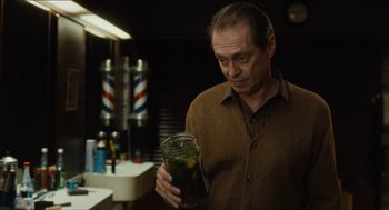 Movie still from “The Cobbler” (2014), directed by Tom McCarthy – A man holding a jar in a bathroom; Medium shot, Over the shoulder angle