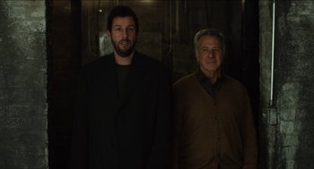 Movie still from “The Cobbler” (2014), directed by Tom McCarthy – Two men standing next to each other in front of a wall; Medium shot, Low angle