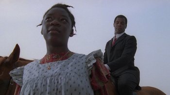 Movie still from “The Color Purple” (1985), directed by Steven Spielberg – A man and a woman standing next to each other; Medium shot, Low angle