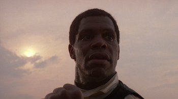 Movie still from “The Color Purple” (1985), directed by Steven Spielberg – A man's face in front of a sunset; Close Up shot, Low angle