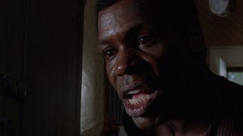 Movie still from “The Color Purple” (1985), directed by Steven Spielberg – A man's teeth with a dark background; Close Up shot, Low angle