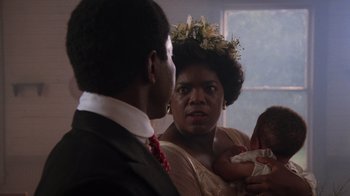 Movie still from “The Color Purple” (1985), directed by Steven Spielberg – An older woman holding a baby in her arms; Close Up shot, Over the shoulder angle