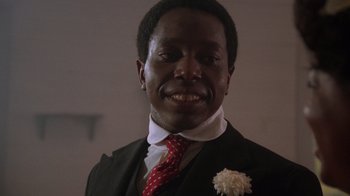 Movie still from “The Color Purple” (1985), directed by Steven Spielberg – A person wearing a suit and tie; Close Up shot, Low angle