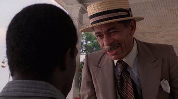Movie still from “The Color Purple” (1985), directed by Steven Spielberg – An older man wearing a straw hat talking to a young man; Close Up shot, Over the shoulder angle