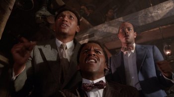 Movie still from “The Color Purple” (1985), directed by Steven Spielberg – A group of men standing next to each other in a room; Close Up shot, Low angle