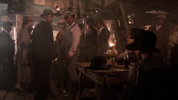 Movie still from “The Color Purple” (1985), directed by Steven Spielberg – A group of people standing around a table; Wide shot, Low angle