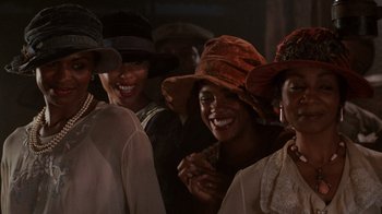 Movie still from “The Color Purple” (1985), directed by Steven Spielberg – A group of people standing next to each other wearing hats; Close Up shot, Low angle