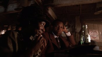 Movie still from “The Color Purple” (1985), directed by Steven Spielberg – Two men sitting next to each other in a room; Close Up shot, Over the shoulder angle
