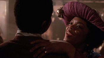 Movie still from “The Color Purple” (1985), directed by Steven Spielberg – A woman is hugging another woman in a room; Close Up shot, Over the shoulder angle