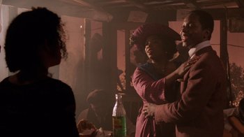 Movie still from “The Color Purple” (1985), directed by Steven Spielberg – A man and a woman are standing in front of a table; Medium shot, Over the shoulder angle
