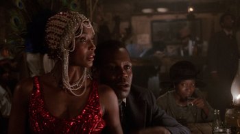 Movie still from “The Color Purple” (1985), directed by Steven Spielberg – A man and a woman sitting next to each other in a room; Close Up shot, Over the shoulder angle