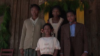 Movie still from “The Color Purple” (1985), directed by Steven Spielberg – A group of young people standing next to each other in front of a tree; Medium shot, Low angle