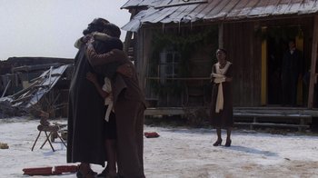 Movie still from “The Color Purple” (1985), directed by Steven Spielberg – A group of people hugging in front of a wooden house; Wide shot, Low angle