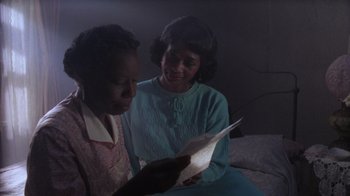 Movie still from “The Color Purple” (1985), directed by Steven Spielberg – Two women are looking at a sheet of paper in the dark; Close Up shot, High angle