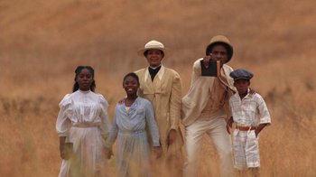 Movie still from “The Color Purple” (1985), directed by Steven Spielberg – A group of people standing next to each other in a field; Wide shot, High angle