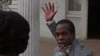 Movie still from “The Color Purple” (1985), directed by Steven Spielberg – A man with his hand up in the air; Close Up shot, Over the shoulder angle