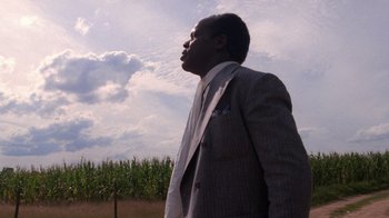 Movie still from “The Color Purple” (1985), directed by Steven Spielberg – A man in a suit and tie looking up at the sky; Close Up shot, Low angle