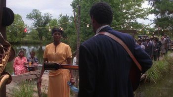 Movie still from “The Color Purple” (1985), directed by Steven Spielberg – A man and a woman are playing a guitar; Medium shot, Over the shoulder angle