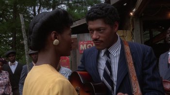 Movie still from “The Color Purple” (1985), directed by Steven Spielberg – A man and a woman standing next to each other holding a guitar; Close Up shot, Over the shoulder angle